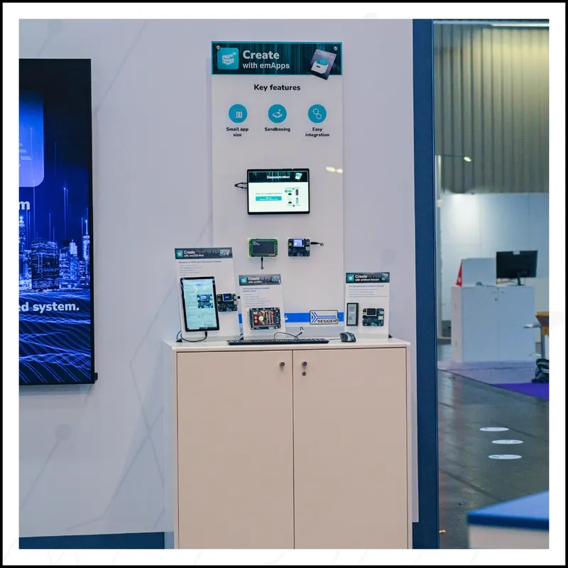 SEGGER emApps live demo station at Embedded World 2026 showing the framework running on multiple development boards with GUI displays